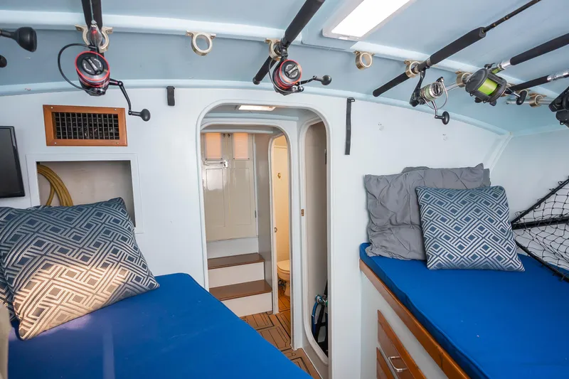 Moby Yacht Photos Pics Interior of 1987 Custom Carolina Island Boatworks 34 Express with fishing rods and cozy bedding.