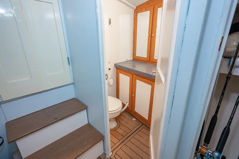 Moby Yacht Photos Pics 1987 Custom Carolina Island Boatworks 34 Express bathroom with wooden cabinets and toilet.