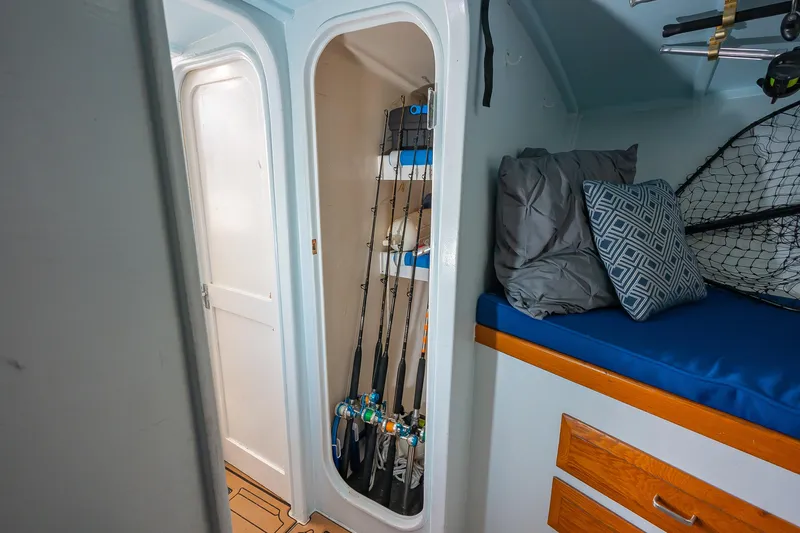 Moby Yacht Photos Pics Interior of 1987 Custom Carolina Island Boatworks 34 Express with fishing rods and cozy bedding.