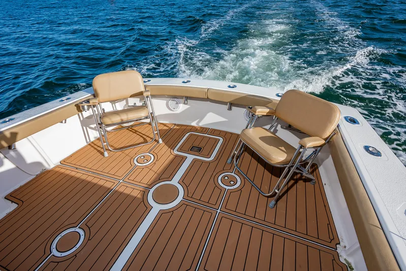 Moby Yacht Photos Pics 1987 Custom Carolina Island Boatworks 34 Express, spacious deck with chairs, cruising on water.