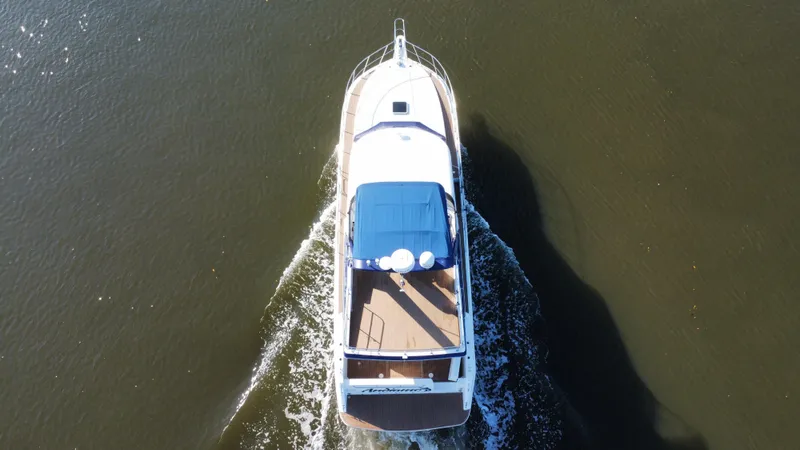 Andiamo Yacht Photos Pics Aerial view of 1998 Navigator Pilothouse boat cruising on water.