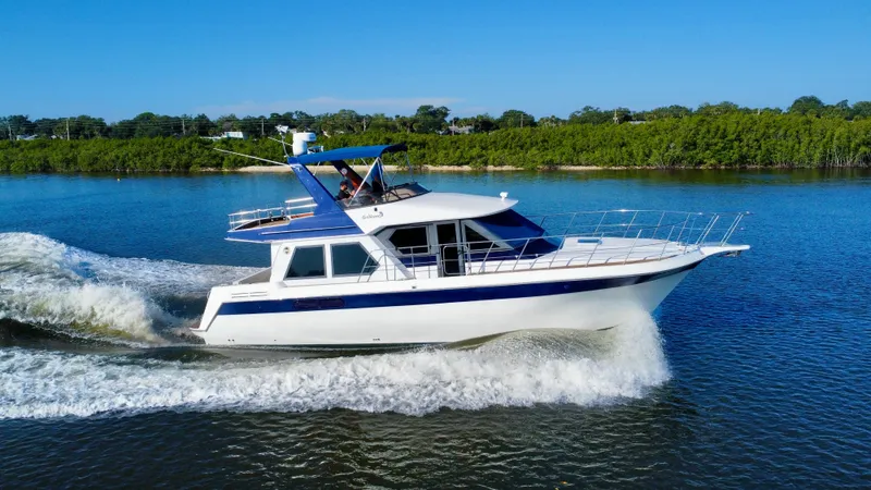 Andiamo Yacht Photos Pics 1998 Navigator Pilothouse yacht cruising on a serene lake.