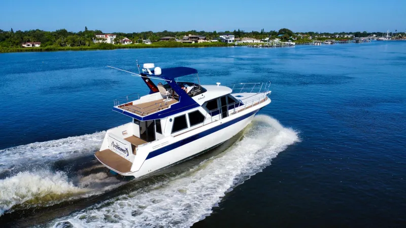 Andiamo Yacht Photos Pics 1998 Navigator Pilothouse yacht cruising on a serene blue lake.