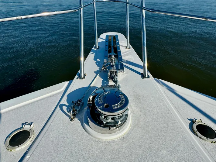 Andiamo Yacht Photos Pics 1998 Navigator Pilothouse boat deck with anchor and railing on calm water.