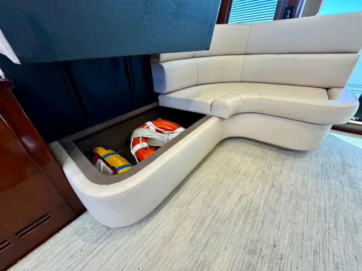 Andiamo Yacht Photos Pics 1998 Navigator Pilothouse interior with storage under beige seating, containing life jackets.