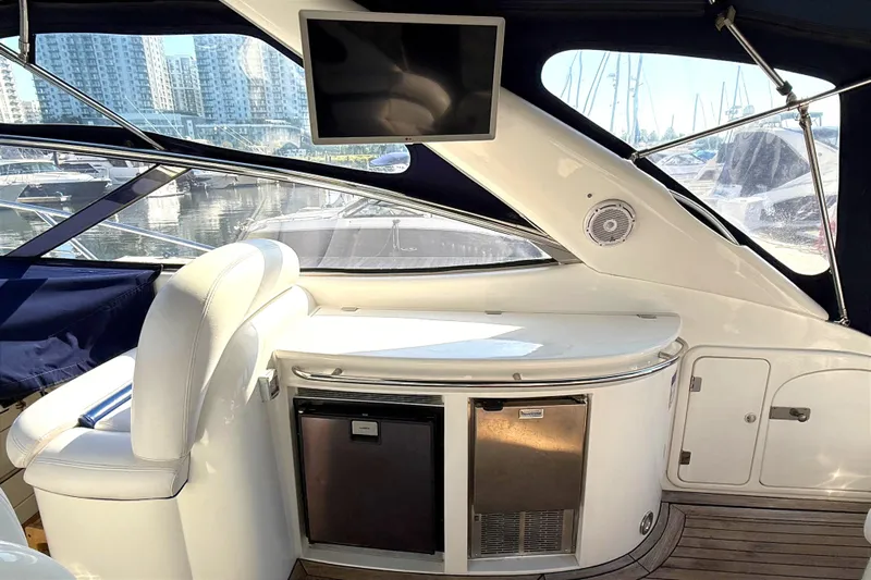  Yacht Photos Pics Interior of 2002 Sunseeker Camargue 44 yacht with seating, fridge, and TV.