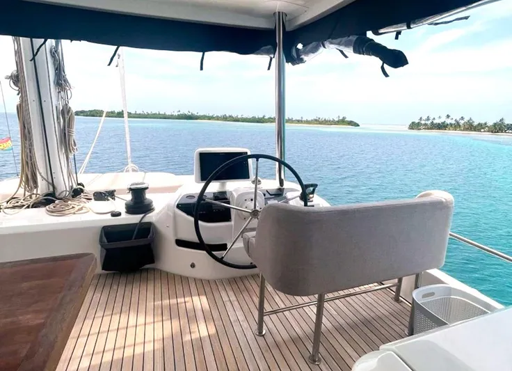 Elora Yacht Photos Pics 2023 Lagoon 55 yacht helm with ocean view and tropical island background.