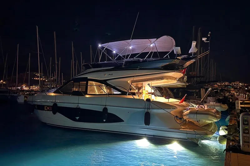  Yacht Photos Pics Luxurious 2023 Princess F45 yacht illuminated at night in a marina setting.