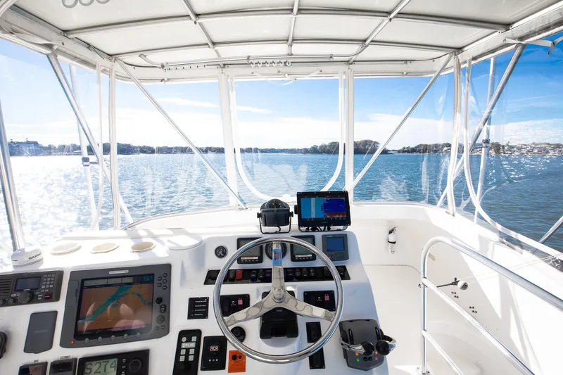 Jenn-a Yacht Photos Pics Helm of 2007 Luhrs Tournament 360 Open boat with navigational equipment, overlooking serene waters.