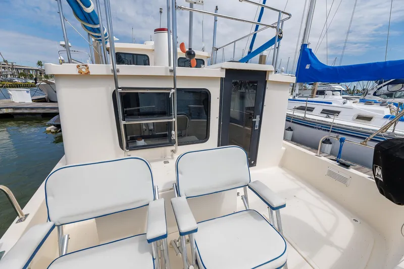  Yacht Photos Pics Nordic Tug 32 (2000) boat deck with seating, docked at marina.