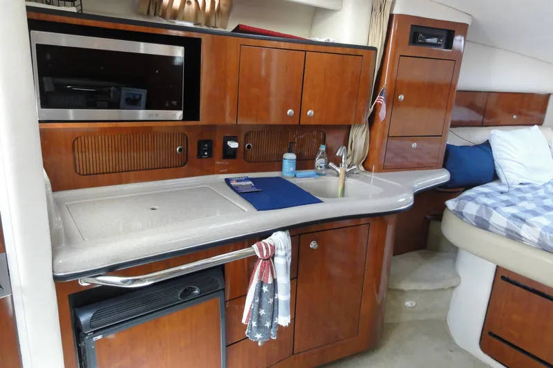  Yacht Photos Pics Interior of 2007 Sea Ray 320 Sundancer with kitchenette and cozy sleeping area.