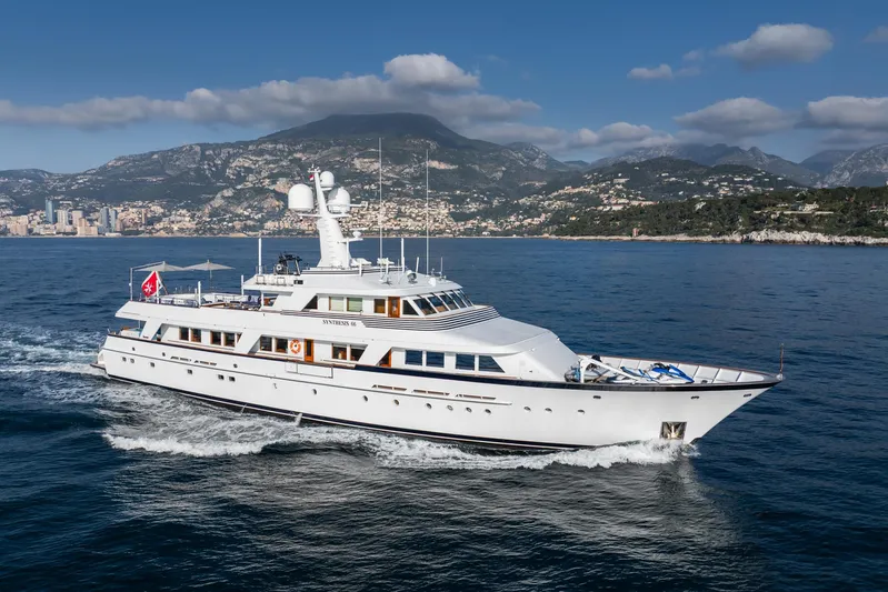 Synthesis 66 Yacht Photos Pics Luxurious 1982 Feadship yacht cruising near scenic coastline under blue skies.