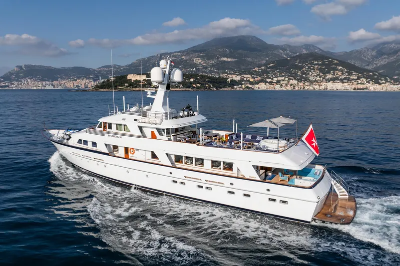 Synthesis 66 Yacht Photos Pics Luxurious 1982 Feadship yacht cruising near scenic coastal mountains.