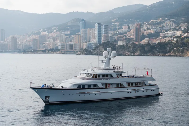 Synthesis 66 Yacht Photos Pics Luxury 1982 Feadship yacht cruising near a coastal city skyline.