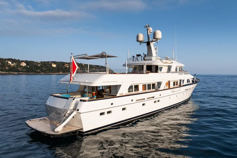 Synthesis 66 Yacht Photos Pics 1982 Feadship yacht cruising on calm waters with scenic coastline in the background.