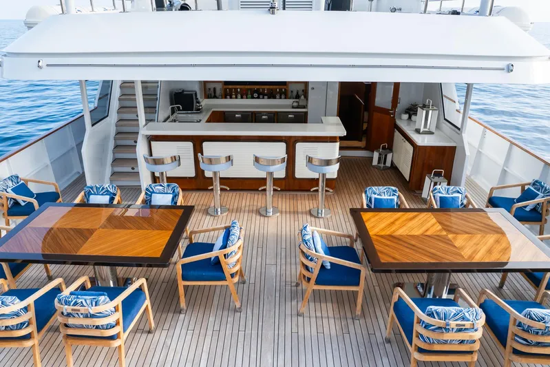Synthesis 66 Yacht Photos Pics Luxurious 1982 Feadship yacht deck with bar, dining tables, and ocean view.