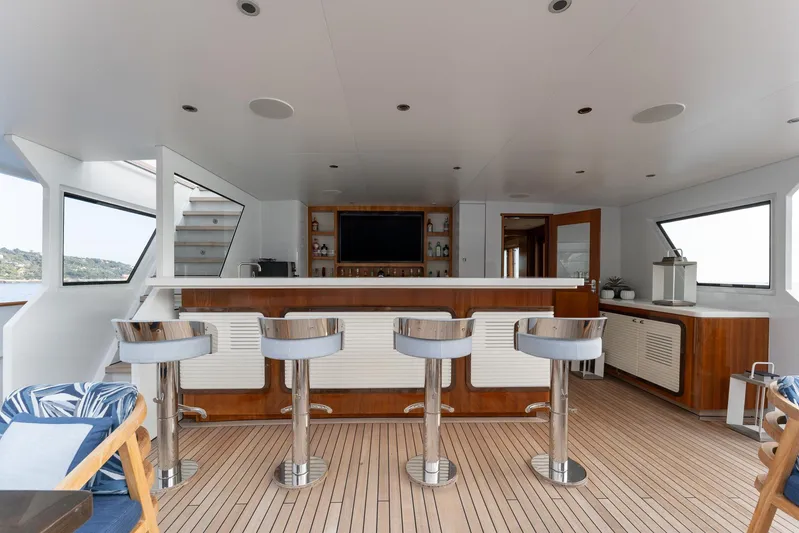 Synthesis 66 Yacht Photos Pics Luxurious yacht interior with bar stools, wooden flooring, and modern amenities on a 1982 Feadship model.