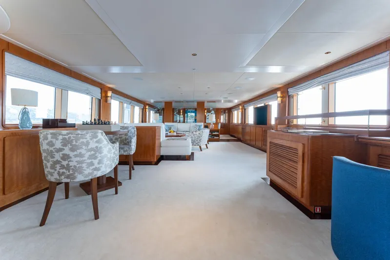 Synthesis 66 Yacht Photos Pics Luxurious interior of 1982 Feadship yacht with elegant seating and large windows.