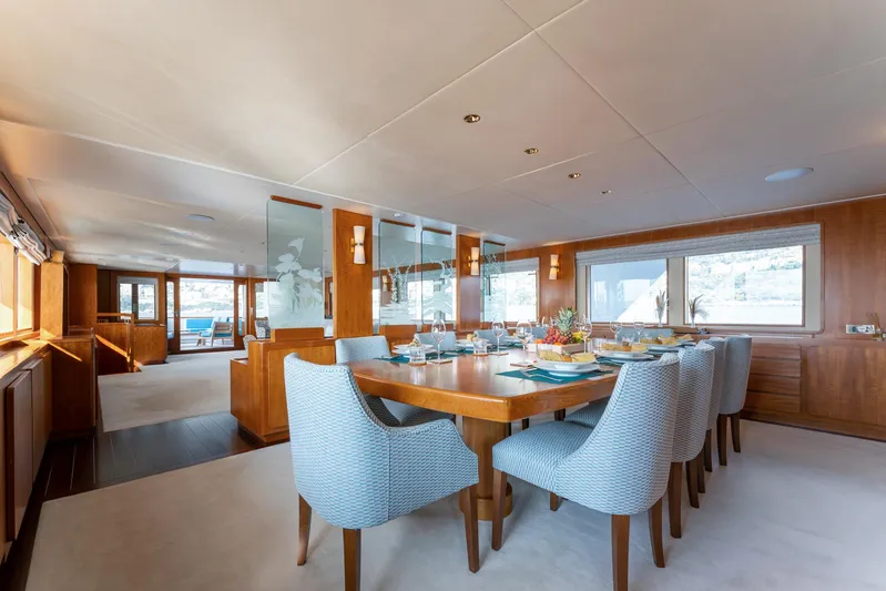 Synthesis 66 Yacht Photos Pics Luxurious dining area on 1982 Feadship yacht with elegant table and chairs.
