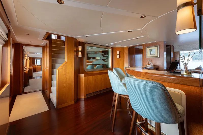 Synthesis 66 Yacht Photos Pics Luxurious 1982 Feadship yacht interior with elegant wood finishes and modern bar seating.