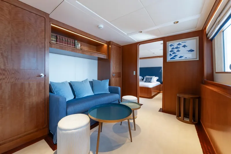 Synthesis 66 Yacht Photos Pics Luxurious Feadship yacht interior with blue sofa, wooden accents, and elegant decor, built in 1982.
