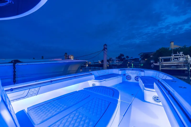  Yacht Photos Pics 2020 Contender 44 ST boat with blue LED lighting at dusk in a marina.