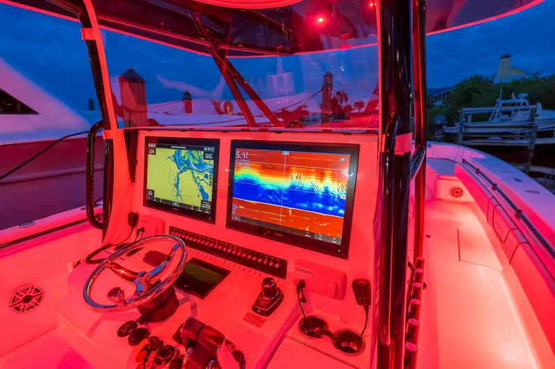  Yacht Photos Pics 2020 Contender 44 ST boat cockpit with illuminated navigation screens and red lighting.