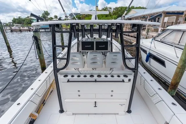 Yacht Photos Pics 2020 Contender 44 ST boat interior with helm, seats, and navigation screens at a marina.