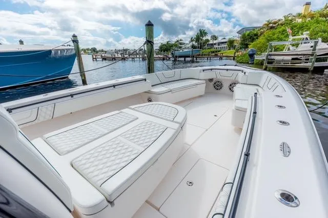  Yacht Photos Pics 2020 Contender 44 ST boat with spacious seating, docked at a marina under a cloudy sky.