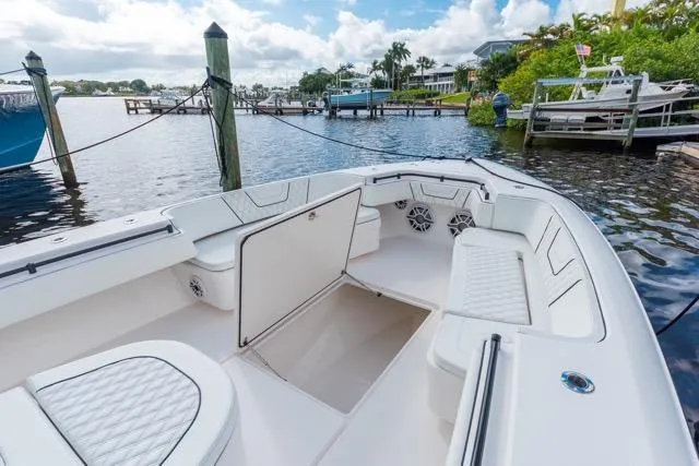  Yacht Photos Pics 2020 Contender 44 ST boat interior with white seating, docked by a scenic waterfront.