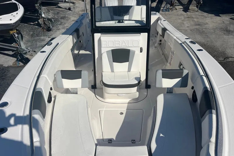  Yacht Photos Pics 2025 Robalo R270 Center Console boat interior with seating and console, docked outdoors.