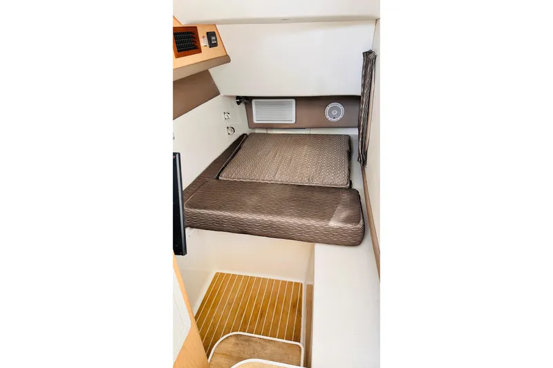 Yacht Photos Pics 2019 World Cat 320 DC cabin interior with cushioned bed and wooden flooring.