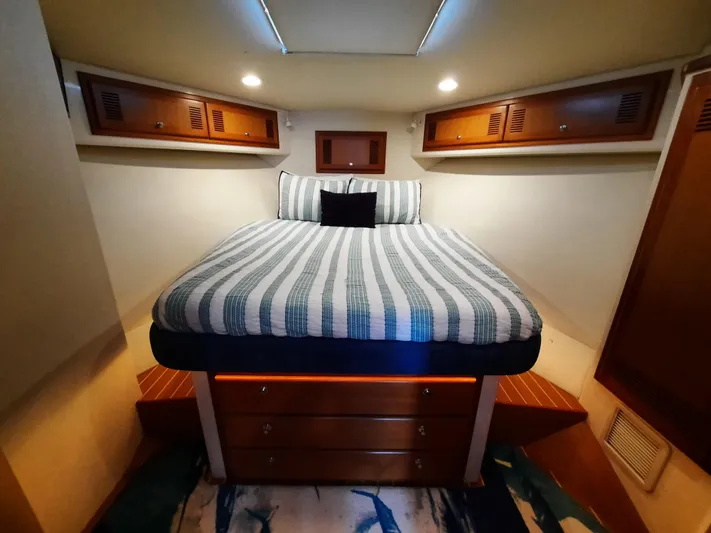 Foam O Yacht Photos Pics Interior of 2000 Cabo 45 Express with cozy bed and wooden cabinets.