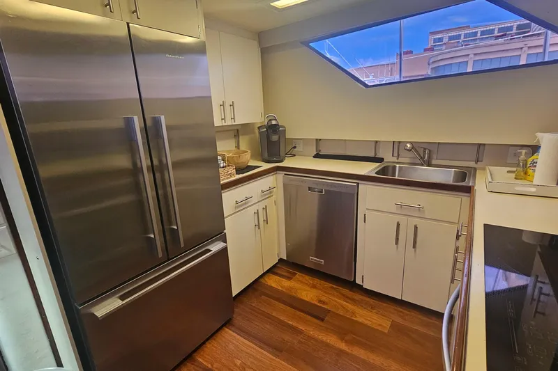 Kokomo Yacht Photos Pics Modern kitchen in 1990 Hatteras 67 Cockpit Motor Yacht with stainless steel appliances.