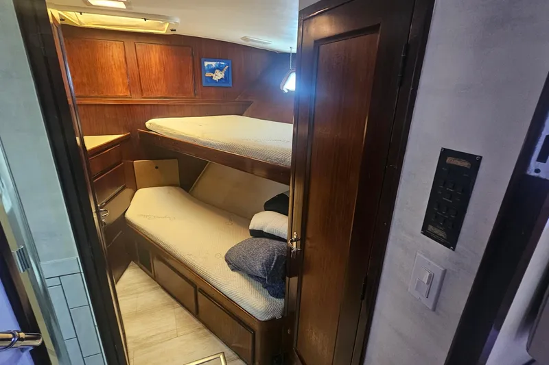 Kokomo Yacht Photos Pics Interior cabin of 1990 Hatteras 67 Cockpit Motor Yacht with wooden bunk beds.