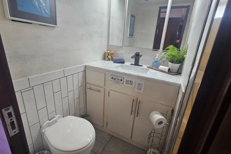 Kokomo Yacht Photos Pics Bathroom interior of 1990 Hatteras 67 Cockpit Motor Yacht with modern fixtures and decor.