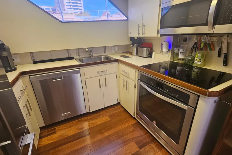 Kokomo Yacht Photos Pics Modern kitchen in 1990 Hatteras 67 Cockpit Motor Yacht with stainless steel appliances.