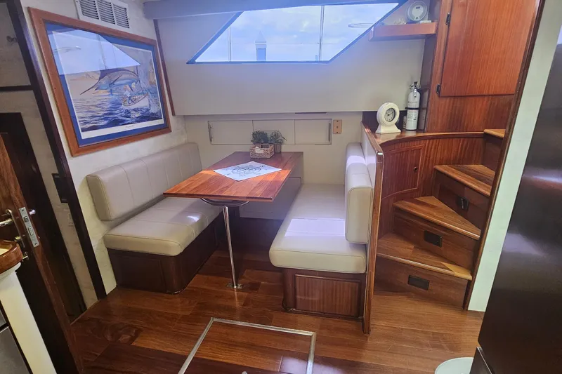 Kokomo Yacht Photos Pics Interior of 1990 Hatteras 67 Cockpit Motor Yacht with dining area and wooden stairs.