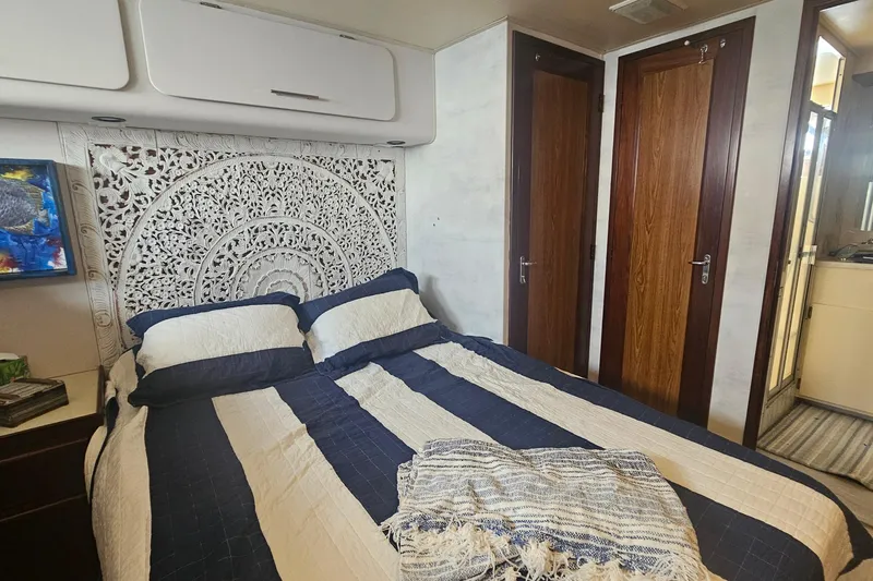 Kokomo Yacht Photos Pics Luxurious bedroom interior of 1990 Hatteras 67 Cockpit Motor Yacht with elegant decor.