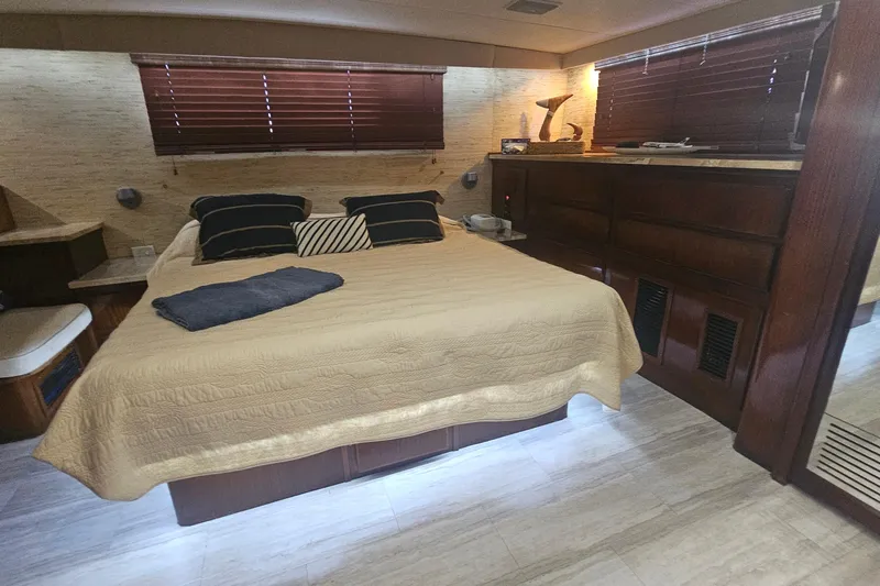 Kokomo Yacht Photos Pics Luxurious bedroom interior of 1990 Hatteras 67 Cockpit Motor Yacht with elegant decor.