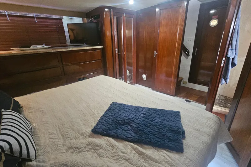Kokomo Yacht Photos Pics Interior of 1990 Hatteras 67 Cockpit Motor Yacht with cozy bedroom and wooden cabinetry.