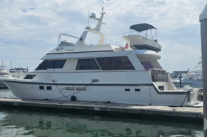 Kokomo Yacht Photos Pics 1990 Hatteras 67 Cockpit Motor Yacht docked at marina under cloudy sky.