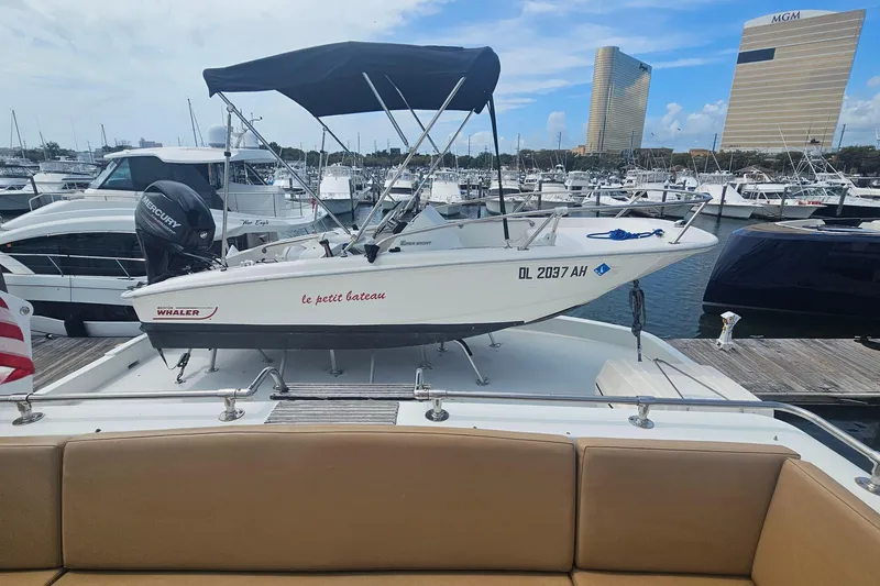 Kokomo Yacht Photos Pics 1990 Hatteras 67 Cockpit Motor Yacht with small boat on deck, marina background.
