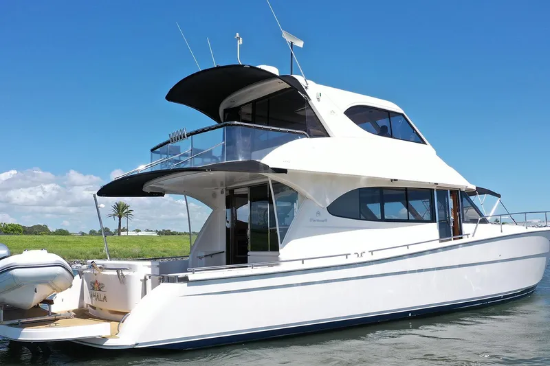 Kahala Yacht Photos Pics 2005 Maritimo M60 yacht on water, clear sky, lush green background.