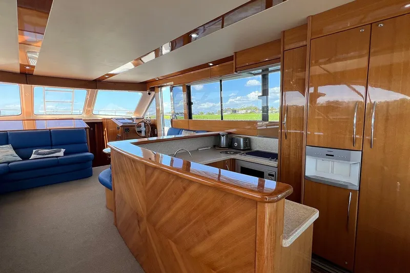 Kahala Yacht Photos Pics Luxurious interior of 2005 Maritimo M60 yacht with wooden cabinetry and blue seating.