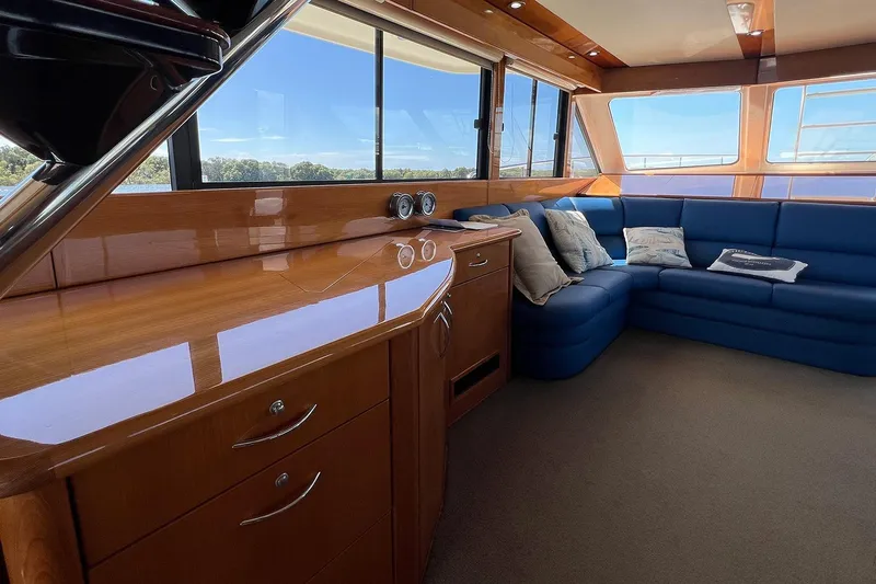 Kahala Yacht Photos Pics Luxurious interior of 2005 Maritimo M60 yacht with blue seating and wooden cabinetry.