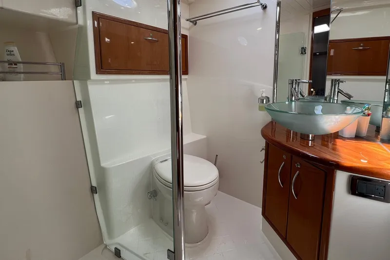 Kahala Yacht Photos Pics Luxurious bathroom in 2005 Maritimo M60 yacht with glass sink and wooden cabinetry.
