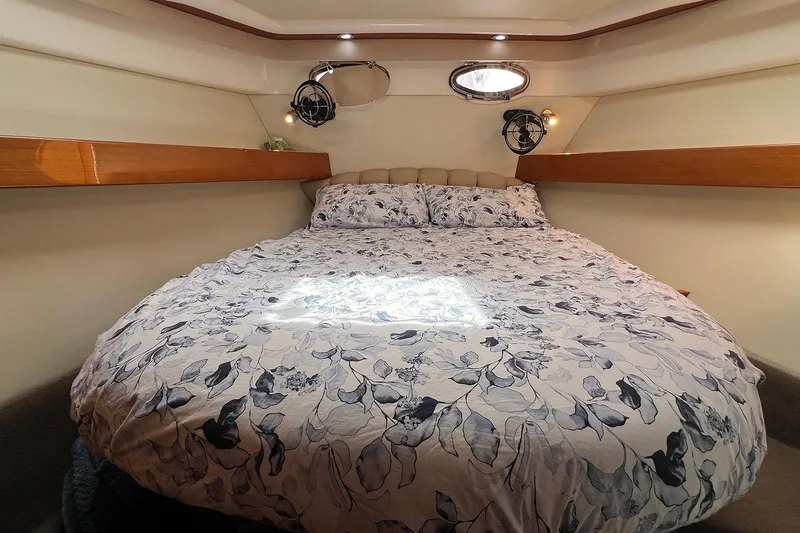 Kahala Yacht Photos Pics Luxurious bedroom interior of 2005 Maritimo M60 yacht with floral bedding and porthole windows.
