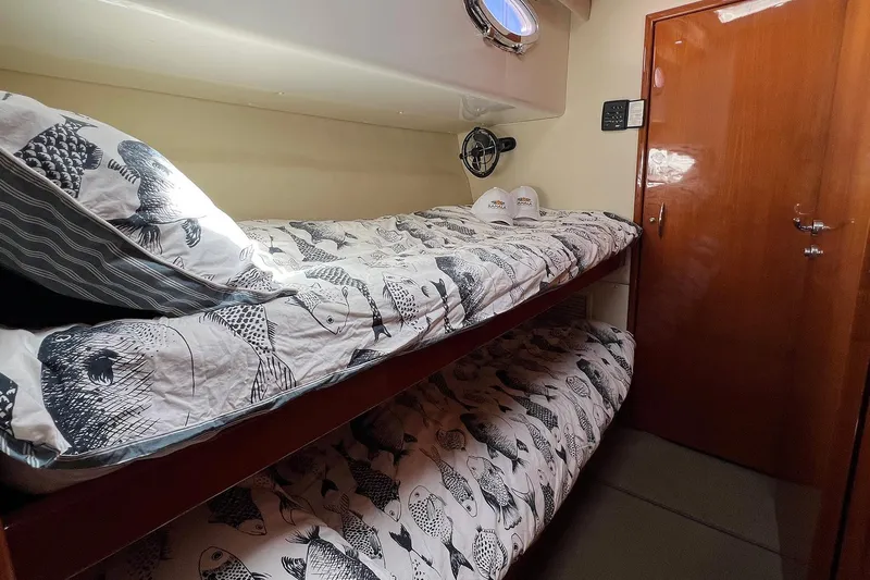 Kahala Yacht Photos Pics Cozy cabin with bunk beds in 2005 Maritimo M60 yacht, featuring fish-patterned bedding.