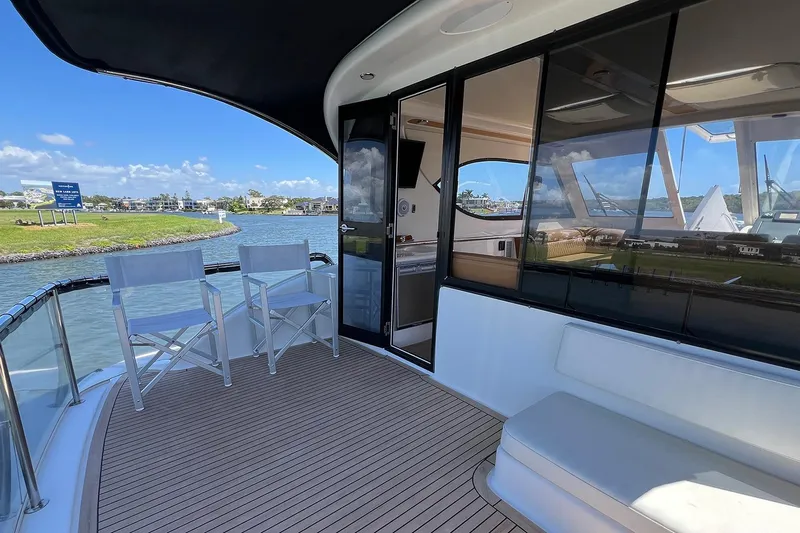 Kahala Yacht Photos Pics 2005 Maritimo M60 yacht deck with seating, overlooking serene waterfront view.